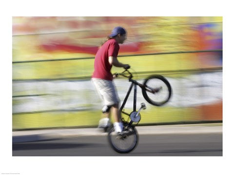 Side profile of a teenage boy performing a stunt on a bicycle