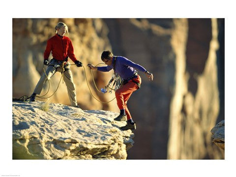 Two hikers with ropes at the edge of a cliff