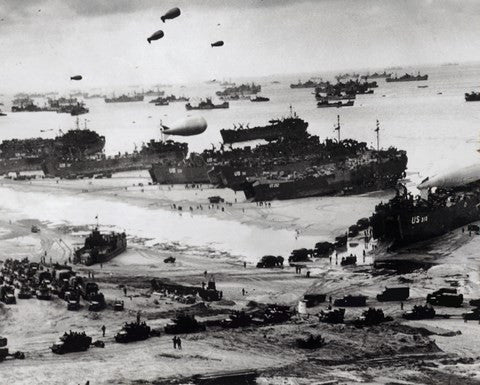 Fleets of US transport and landing craft disgorge reinforcements and supplies for the US troops